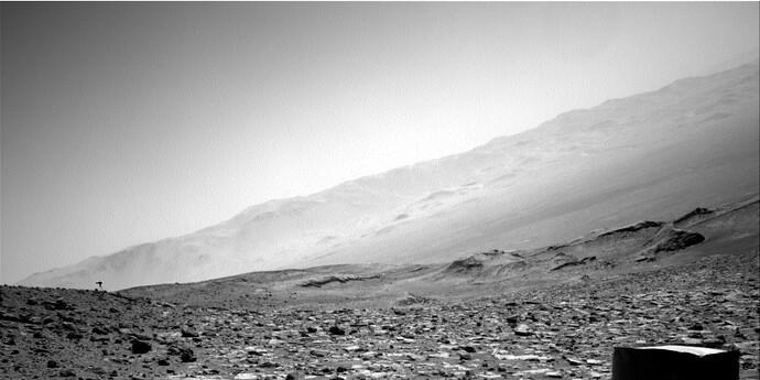 A full navigation-camera frame from NASA's Curiosity rover shows a small dark mark near the far-left horizon.